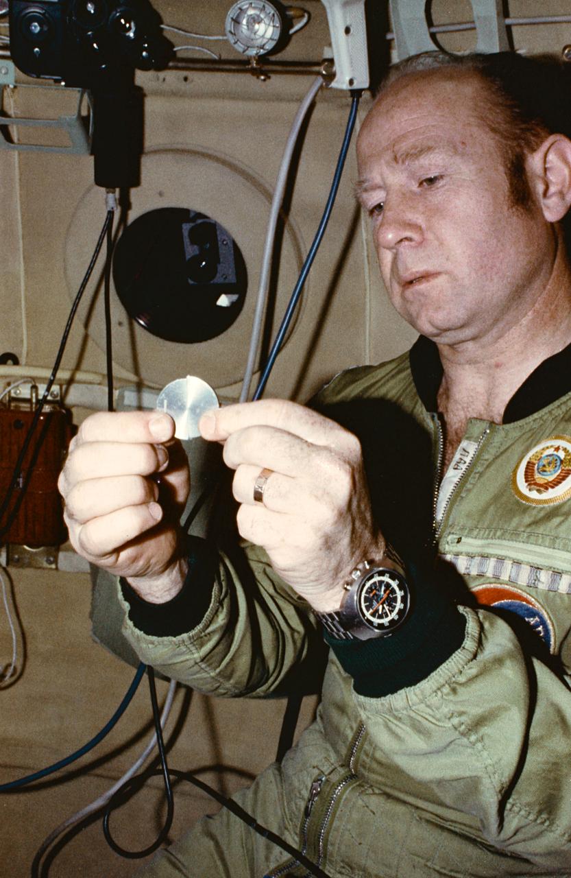 S75-24926 (April 1975) --- Cosmonaut Aleksey A. Leonov, commander of the Soviet ASTP prime crew, practices with a training mock-up of the ASTP commemorative medal during Apollo-Soyuz Test Project activity at the Cosmonaut Training Center (Star City) near Moscow.  Leonov is in the Soyuz orbital module trainer. Two medals divided into two halves each will be flown on the mission. The American ASTP crew will carry two halves aboard Apollo; and the Soviet ASTP crew will carry the other two halves aboard Soyuz. The four halves will be joined together to make two complete medals after the two spacecraft rendezvous and dock in Earth orbit. Grooved slots in the halves will allow the medals to be fitted together.  One medal then will be returned to Earth by the astronauts; and the second medal will be brought back by the cosmonauts.