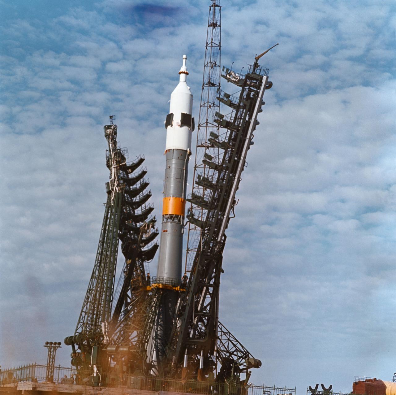 S75-32339 (28 Jan. 1974) --- A low-angle view of a launch pad at the Baikonur Cosmodrome in Kazakhstan showing the installation of a Soyuz spacecraft and its launch vehicle. The 49.3-meter-high (162 feet) space vehicle is composed of the three-stage booster, a three-module, two-man Soyuz spacecraft and a launch escape system. The weight of the space vehicle at launch is approximately 300,000 kilograms. The first stage vacuum thrust is about 1,000,400 newtons, the second stage is 956,500 newtons, and the third stage is 299,000 newtons. This earlier Soyuz mission illustrates the approximate launch configuration of the Soviet Union?s Apollo-Soyuz Test Project (ASTP) Soyuz space vehicle. PHOTO COURTESY: USSR ACADEMY OF SCIENCES