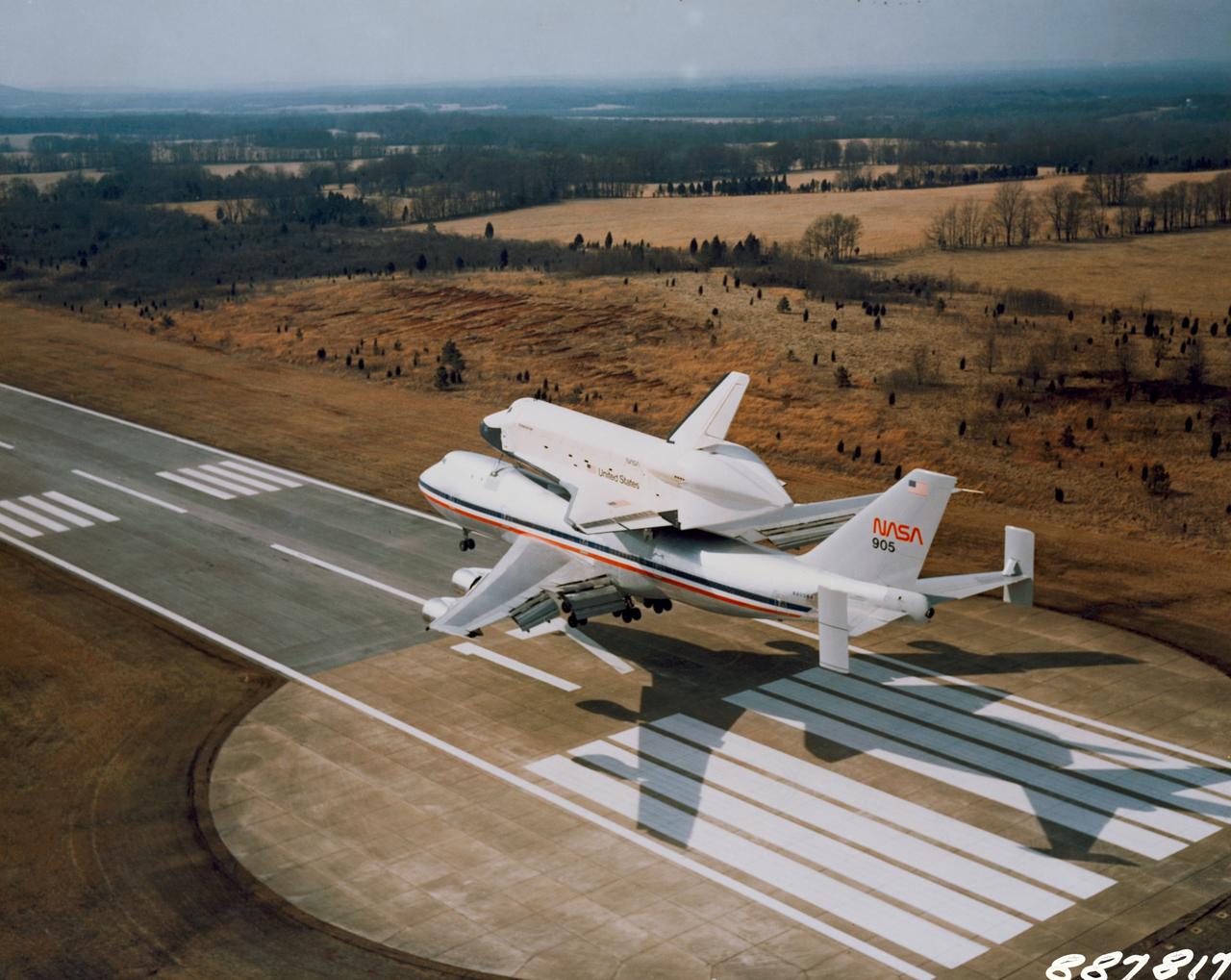 S78-27238 (13 March 1978) --- The space shuttle orbiter 101 Enterprise approaches riding atop its 747 carrier aircraft, arrives at the Redstone Arsenal airstrip near Marshall Space Flight Center (MSFC), Huntsville, Alabama, on March 13, 1978. It is to undergo ground vibration tests along with the external tank and solid rocket boosters, in preparation for Orbiter Flight Tests (OFT) in which its successor craft (Orbiter 102) will take several two-man crews into Earth orbit. Photo credit: NASA