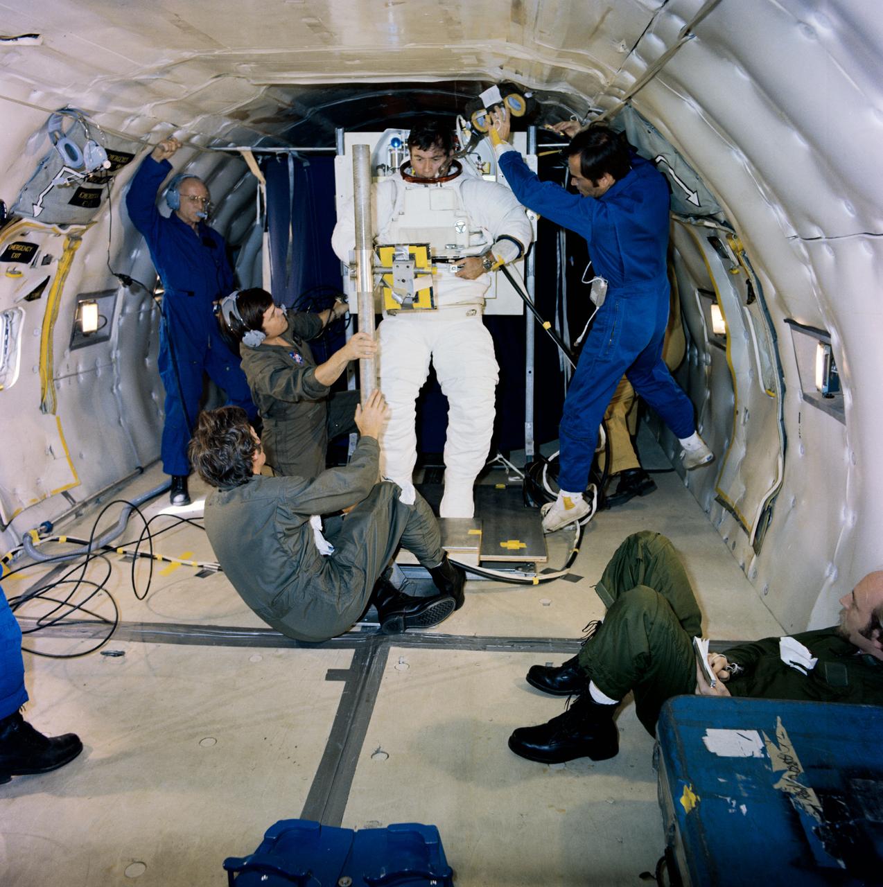 S79-30347 (31 March 1979) --- Taking advantage of a brief period of zero-gravity afforded aboard a KC-135 flying a parabolic curve, the flight crew of the first space shuttle orbital flight test (STS-1) goes through a spacesuit donning exercise. Astronaut John W. Young has just entered the hard-material torso of the shuttle spacesuit by approaching it from below. He is assisted by astronaut Robert L. Crippen. The torso is held in place by a special stand here, simulating the function provided by the airlock wall aboard the actual shuttle craft. The life support system is mated to the torso on Earth and remains so during the flight, requiring this type of donning and doffing exercise. Note Crippen?s suit is the type to be used for intravehicular activity in the shirt sleeve environment to be afforded aboard shuttle. The suit worn by Young is for extravehicular activity (EVA).  Young will be STS-1 commander and Crippen, pilot. They will man the space shuttle orbiter 102 Columbia. Photo credit: NASA
