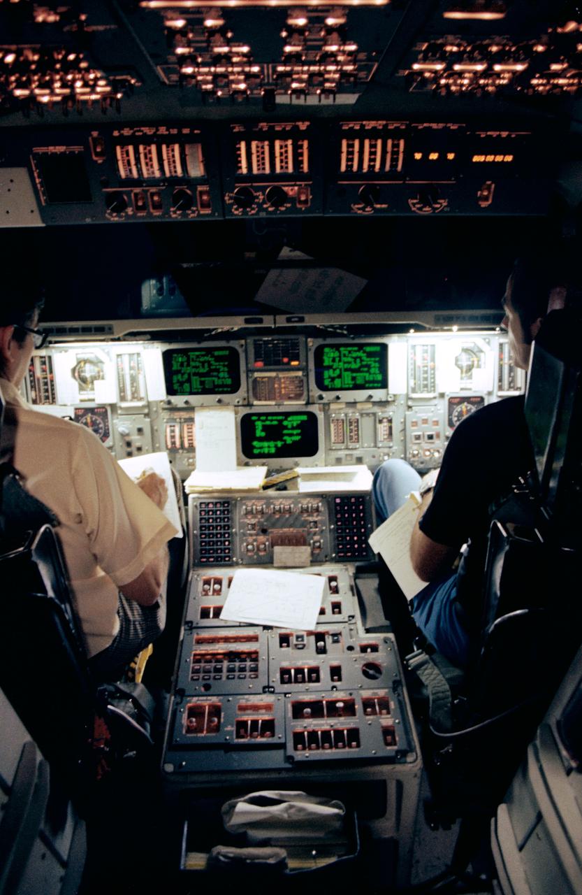 S79-31075 (5 April 1979) --- Astronauts John W. Young, left, and Robert L. Crippen, crewmen for the first space transportation system (STS-1) mission, go over a check off list during simulations in the Johnson Space Center?s shuttle mission simulator in the mission simulation and training facility. Young will be crew commander and Crippen, pilot, for the mission-shuttle?s initial orbital flight test (OFT). Photo credit: NASA