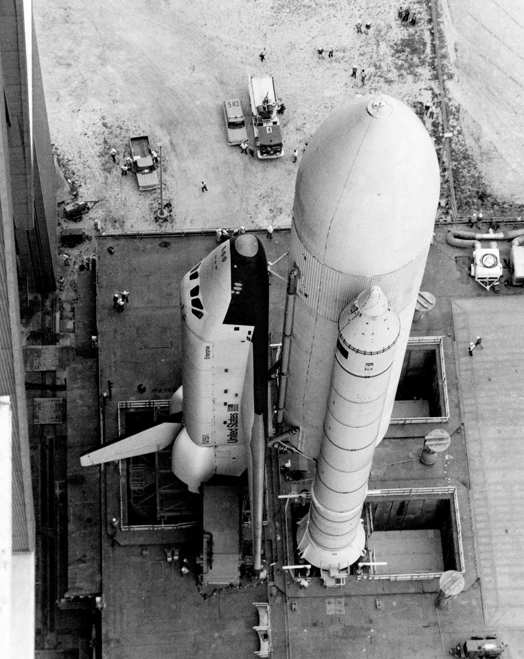 S79-31980 (1 May 1979) --- Space shuttle orbiter 101 Enterprise makes its first appearance mated to supportive propellant containers/boosters cluster, as it is slowly rolled out the front door of the huge Vehicle Assembly Building (VAB) at Kennedy Space Center en route to the launch pad, some 3.5  miles away. It will move slowly there atop this large mobile launch platform. The Enterprise is to undergo several weeks of fit and function checks on the pad in preparation for STS-1, on which its sister craft Columbia will take astronauts John W. Young and Robert L. Crippen into space for a 54-hour test mission. Photo credit: NASA