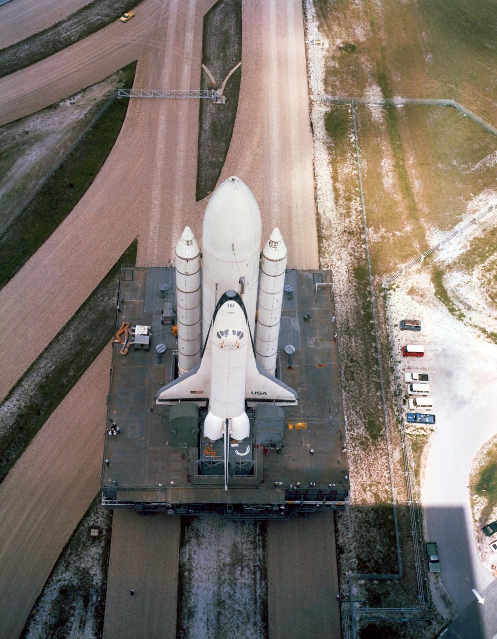 S79-35236 (23 July 1979) --- The space shuttle orbiter 101 Enterprise is seen in this high angle view as it is being moved from Pad A, Launch Complex 39 at the Kennedy Space Center (KSC) to the Vehicle Assembly Building (VAB).  Though only 3.5 miles separate the launch pad and the VAB, the journey of the orbiter, its solid rocket boosters and external tank takes more than 11 hours. The move back to the VAB represents the end of several weeks of fit and function checks performed on the vehicle, prepatory to eventual launch readiness of the first actual flight vehicle in the orbiter flight test (OFT) series -- the Columbia. The SRB/ET/Enterprise cluster will soon be taken apart inside the VAB and the orbiter will be taxied back to the Palmdale, California manufacturing facility of Rockwell International. Photo credit: NASA
