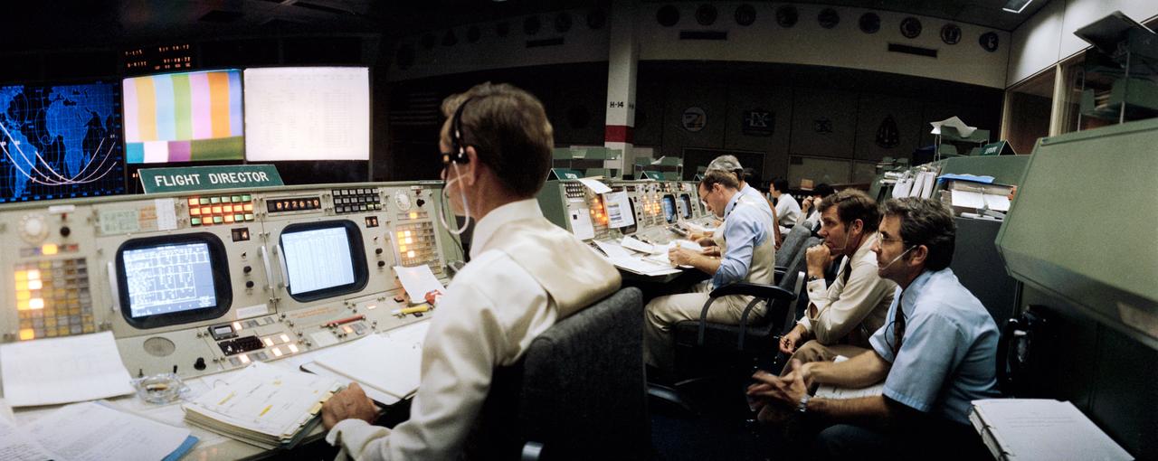 S81-30386 (14 April 1981) --- Flight director Charles R. Lewis, left, studies a chart display on his console?s monitor in the mission operations control room (MOCR) in the Johnson Space Center?s Mission Control Center. The photograph was taken just prior to a TV transmission on day two of STS-1, with a special wide-angle lens. Astronauts Joe H. Engle (second from right) and Richard H. Truly, right, are backup commander and pilot, respectively, for NASA?s first space shuttle orbital test mission. Astronaut James F. Buchli, spacecraft communicator, is at right center. Photo credit: NASA