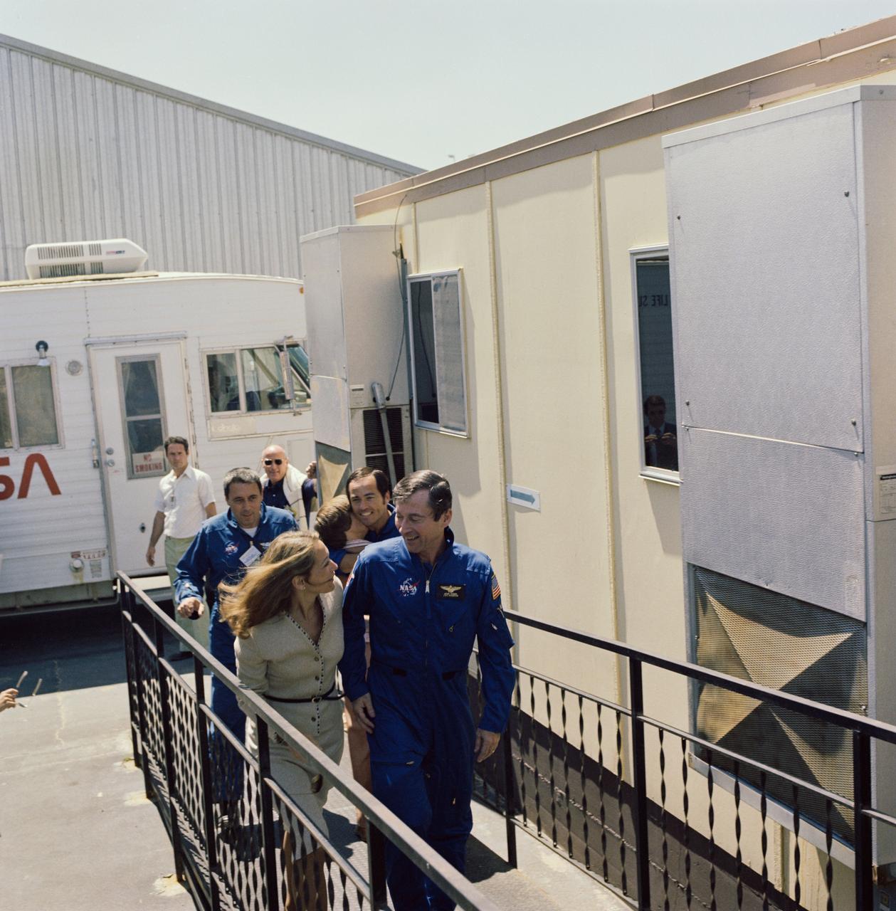 Astronaut Robert L. Crippen, right, is greeted by wife Virginia following landing of mission STS-1. Behind Mrs. Crippon is George W.S. Abbey, Director of Flight Operations at JSC (30850); Astronaut John W. Young, right, and Robert L. Crippen, center, are greeted by wives Susy and Virginia after completing STS-1 mission. Near left is George W. S. Abbey (30851).