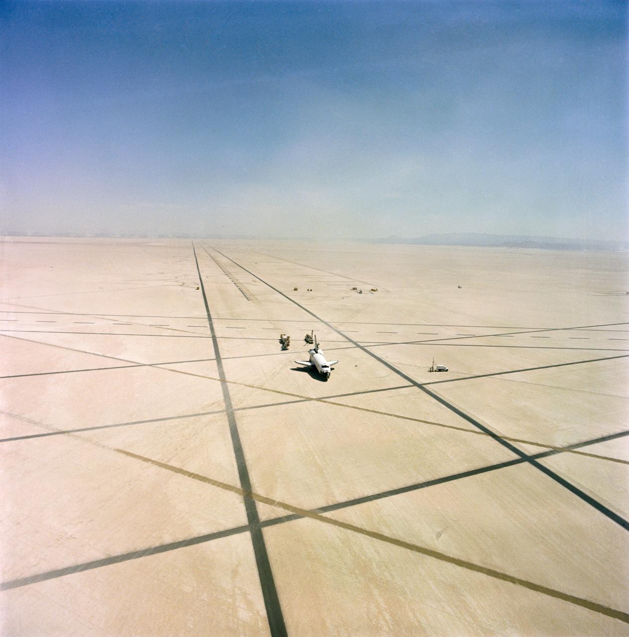 Documentary aerial and ground views of the Columbia sitting on the Lakebed Runway with the deservicing trucks following the STS-1 Mission, 04/14/1981. EAFB, CA Also available in 70 CN