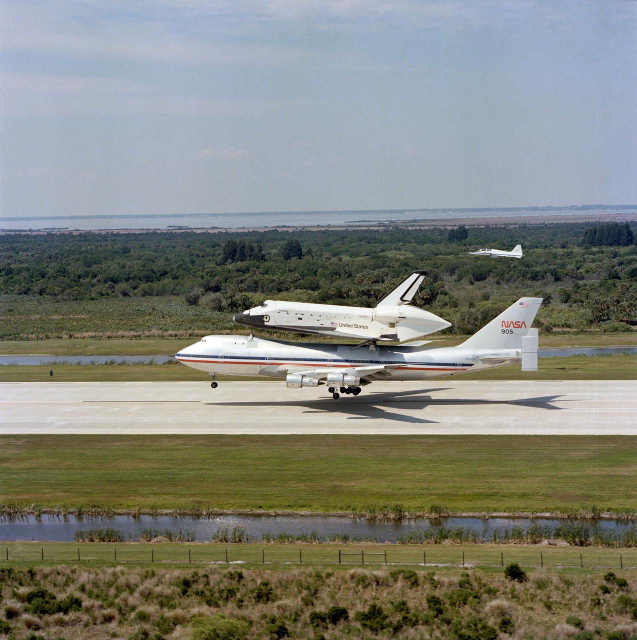 S81-32625 (April 1981) --- This scene represents the end of NASA's STS-1 mission and the beginning of STS-2 in that the orbiter Columbia is arriving at Kennedy Space Center in Florida to begin the lengthy process of preparing it for STS-2. The vehicle landed at Dryden Flight Research Center on April 14 after an historic 2 1/3 day flight in Earth orbit. It was mated to this 747 aircraft, titled NASA 905, and flown over the USA to its Florida destination. It was later removed from atop NASA 905 and moved to the orbiter processing facility for the beginning of refurbishment. Photo credit: NASA