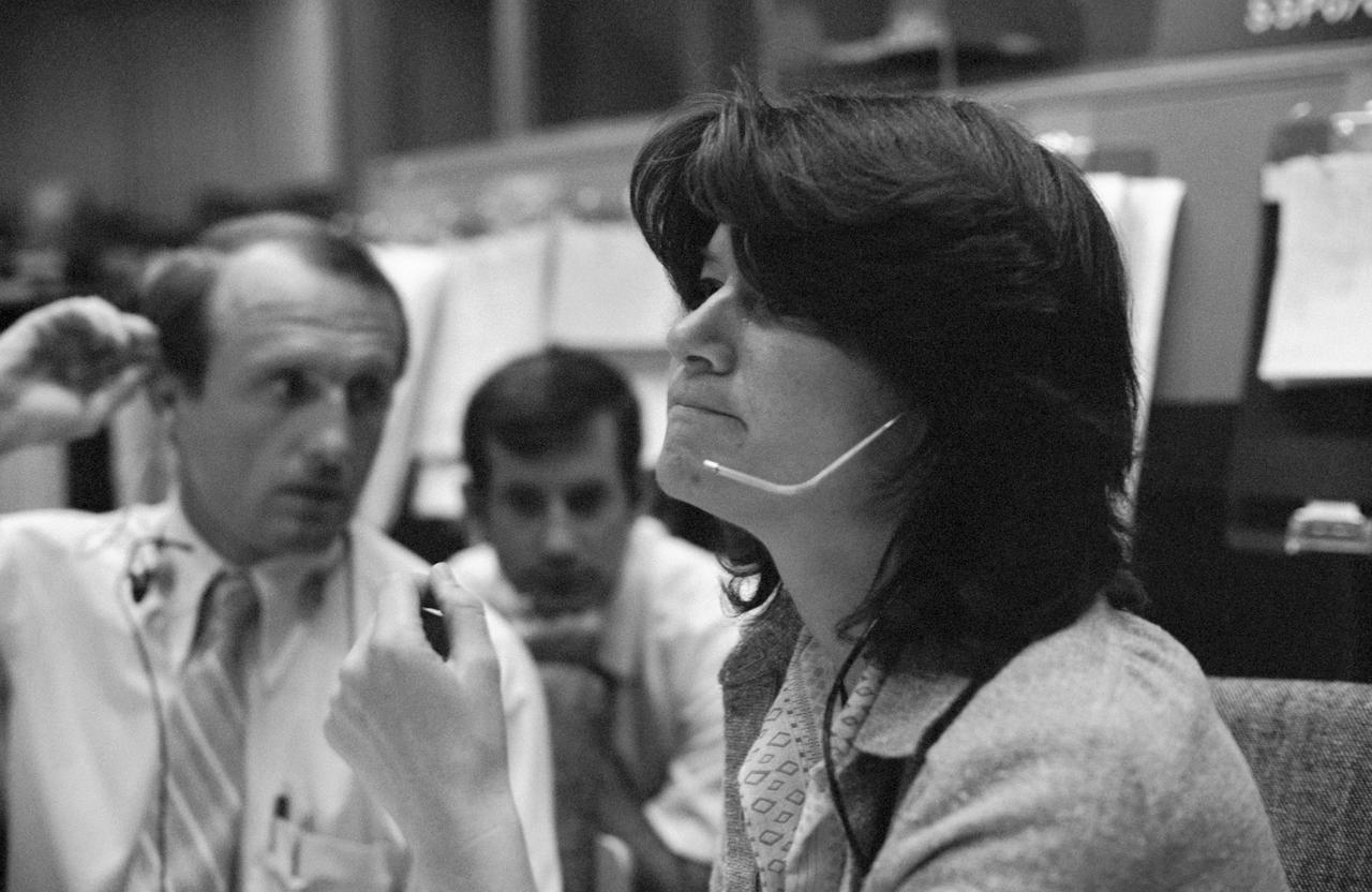 Astronaut Sally Ride at the CapCom console during the STS-2 simulation. She appears to be speaking to the crew using a headset.
