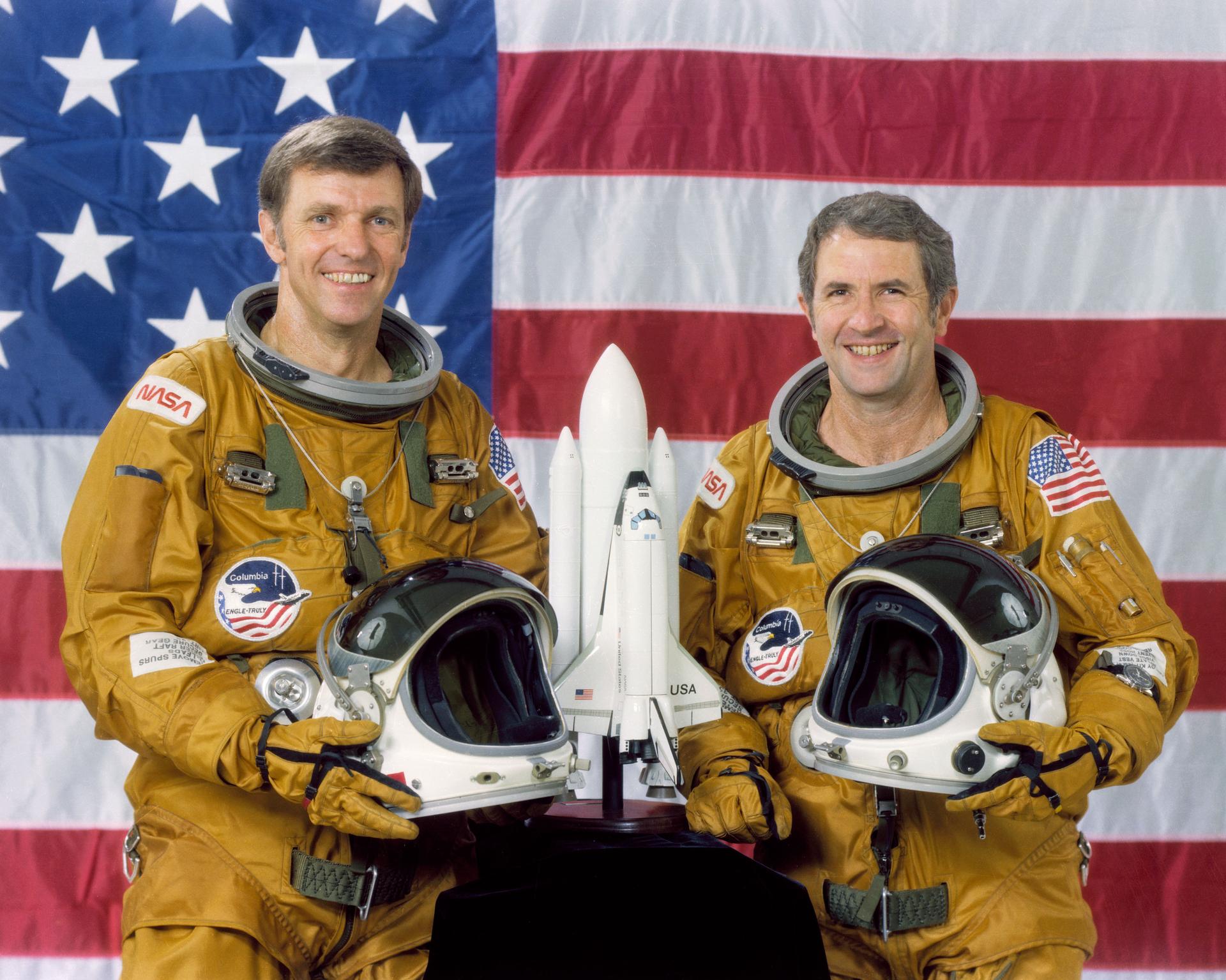 Joe Engle and Richard Truly pose in front of an American Flag for their official STS-2 crew portrait