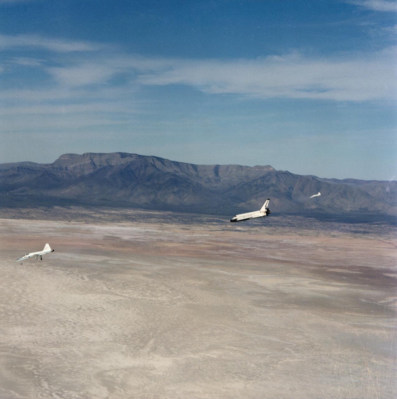 S82-28840 (30 March 1982) --- T-38 chase planes remain relatively close to the NASA reusable space shuttle Columbia (STS-3) as it heads for a completion of an eight-day mission on the White Sands Missile Range's Northrup strip. Astronauts Jack R. Lousma and C. Gordon Fullerton were aboard the craft. This view was photographed from another T-38. Photo credit: NASA