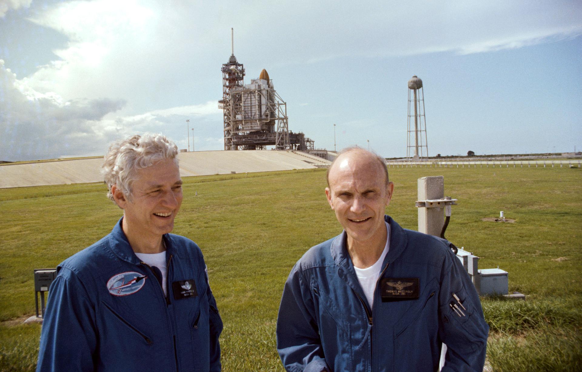 Henry Hartsfield and Ken Mattingly pose in front of the launch pad with Space Shuttle Columbia in the background