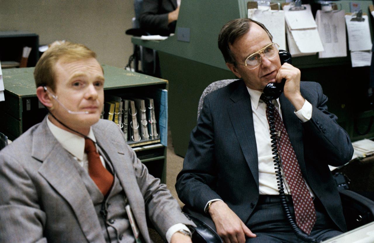 S83-30190 (8 April 1983) ---  Vice President George Bush talks to the Earth-orbiting STS-6 astronauts from the spacecraft communicators; (CAPCOM) console in the mission operations control room (MOCR) of the Johnson Space Center?s mission control center. Astronaut Roy D. Bridges, left, is one of the CAPCOM personnel on duty.