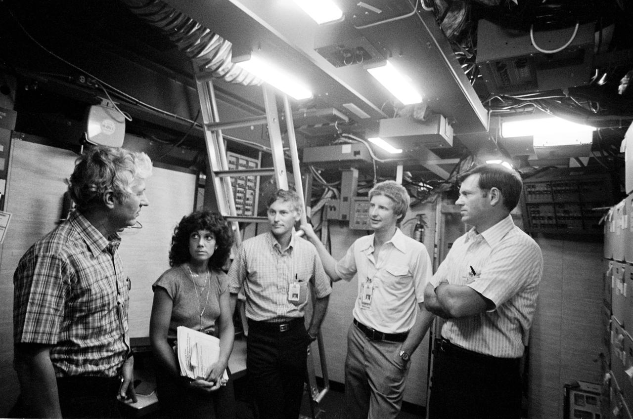View of STS 41-D mission crew training in Shuttle Mission simulator. From left to right are Henry Hartsfield, Jr., commander; mission specialists Judith Resnik, Richard Mullane, and Steven Hawley; and Michael Coats, pilot. They appear to be standing in the middeck mockup, preparing for training.
