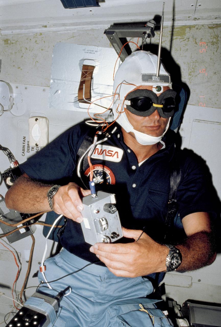 S83-35770 (18?24 June 1983)--- Astronaut Norman E. Thagard, STS-7 mission specialist, is actually performing a medical experiment though his appearance resembles popular depictions of an invading alien.  Thagard, a medical doctor, has been assigned a busy project of evaluating physiological reactions of astronauts in space travel.  He is on the middeck of the Earth-orbiting space shuttle Challenger.  Photo credit: NASA