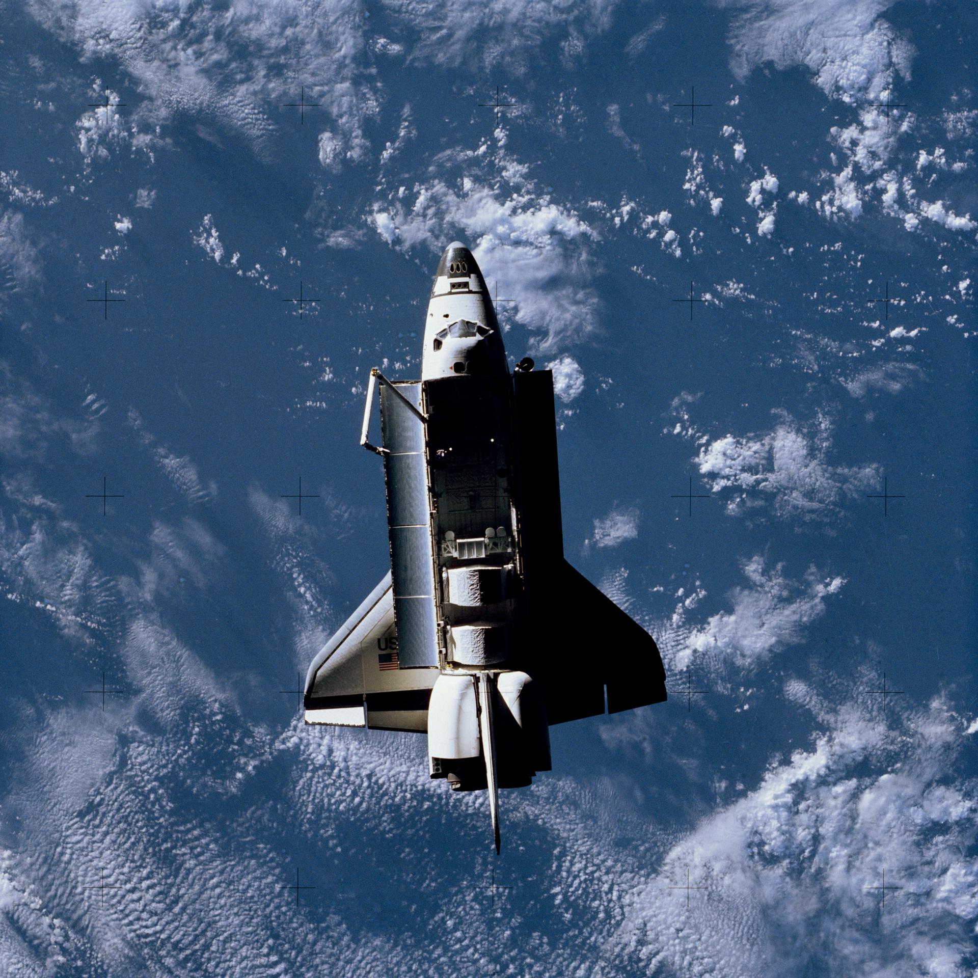 View of Challenger in orbit from above with its payload bay doors open.