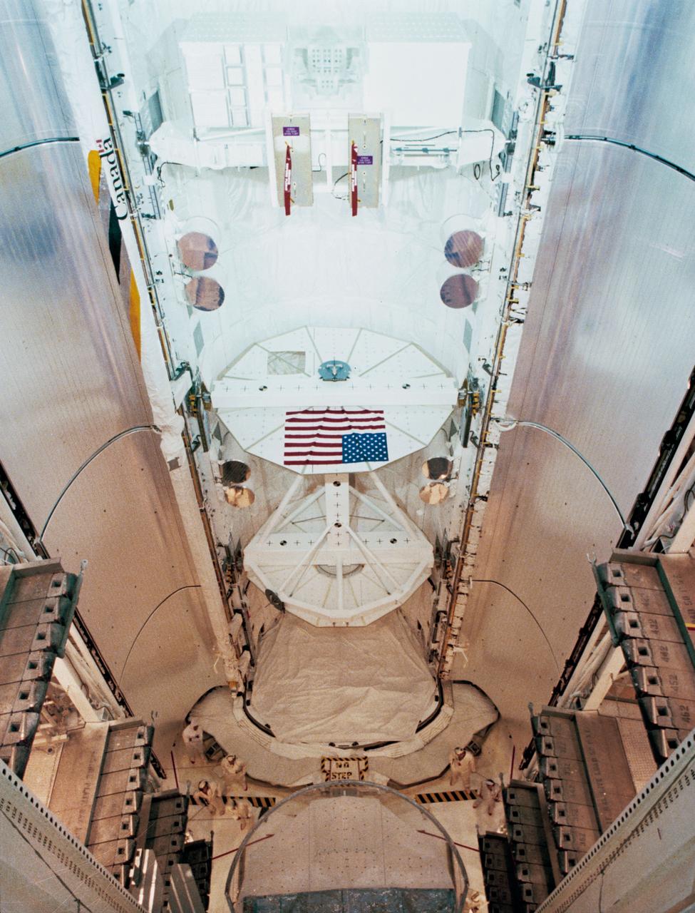 View of the Payload Flight Test Article (PFTA) installed into Challenger's cargo bay in the Payload Changeout Room at Pad 39A at the Kennedy Space Center (KSC). The American flag is visible on one side of the PFTA in the cargo bay. The Kennedy Space Center alternative photo number is KSC-108-83PC-566.