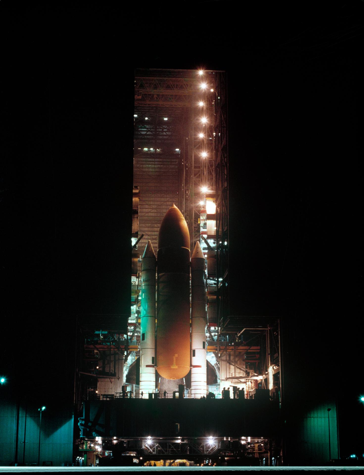 The external tank and solid rocket boosters lit up in a night sky