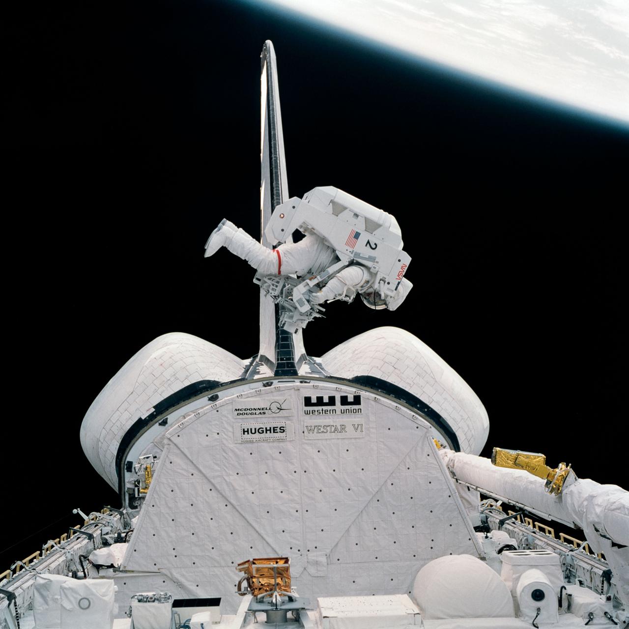 S84-27023 (7 Feb 1984) --- This 70mm frame shows astronaut Bruce McCandless II moving in to conduct a test involving the Trunion Pin Attachment Device (TPAD) he carries and the Shuttle Pallet Satellite (SPAS-01A) partially visible at bottom of frame. SPAS was a stand-in for the damaged Solar Maximum Satellite (SMS) which will be visited for repairs by the STS-41C Shuttle crew in early spring.  This particular Extravehicular Activity (EVA) session was a rehearsal for the SMS visit. The test and the actual visit to the SMS both involve the use of jet-powered, hand-controlled Manned Maneuvering Unit (MMU). The one McCandless uses is the second unit to be tested on this flight. Astronaut Robert L. Stewart got a chance to work with both MMU's on the two EVA's.