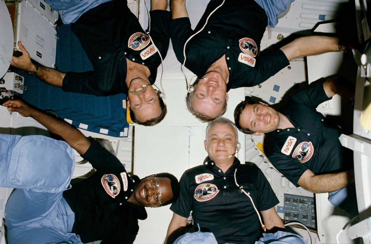 S84-27026 (3-11 Feb. 1984) --- The "star burst" type informal portrait of Space Shuttle crews has become somewhat of a tradition and the five-member STS-41B crew is no exception.      HOLD PICTURE WITH SEMI-CIRCLE AT LOWER RIGHT CORNER.  Counter clockwise from the lower left are Astronauts Vance D. Brand commander; Robert L. Gibson, pilot; and Dr. Ronald E. McNair; Bruce McCandless II and Robert L. Stewart, all mission specialists.  The five are on the mid-deck of the Earth-orbiting Challenger.  The "semi-circle" is actually part of the monodisperse latex reactor (MLR) experiment.  A pre-set 35mm camera was triggered automatically to expose the frame.