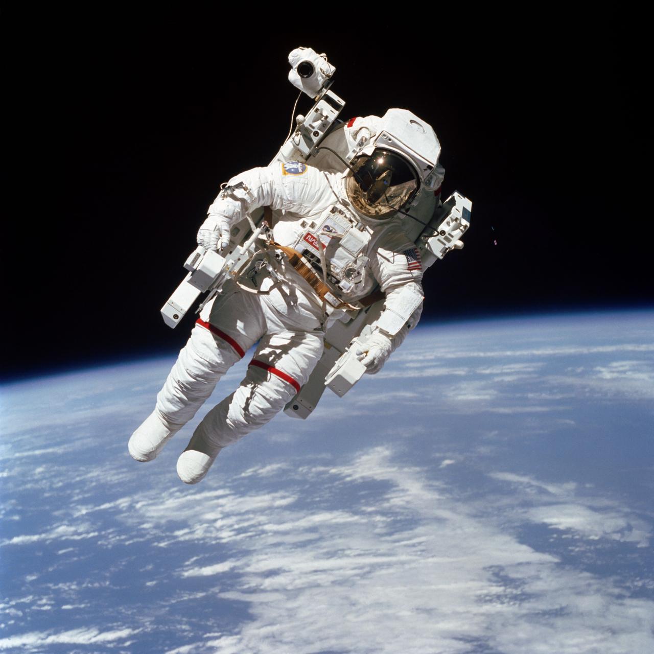 S84-27562 (7 Feb. 1984) --- Astronaut Bruce McCandless II, one of two 41B mission  specialists participating in a historical Extravehicular Activity (EVA), is a few meters away from the cabin of the Earth-orbiting space shuttle Challenger in this 70mm frame. This Extravehicular Activity (EVA) represented the first use of a nitrogen-propelled, hand-controlled device called the Manned Maneuvering Unit (MMU), which allows for much greater mobility than that afforded previous spacewalkers who had to use restrictive tethers. Robert L. Stewart later tried out the MMU McCandless is using here, and the two of them tested another similar unit two days later. Inside the spacecraft were astronauts Vance D. Brand, commander; Robert L. Gibson, pilot; and Ronald E. McNair, mission specialist. Photo credit: NASA
