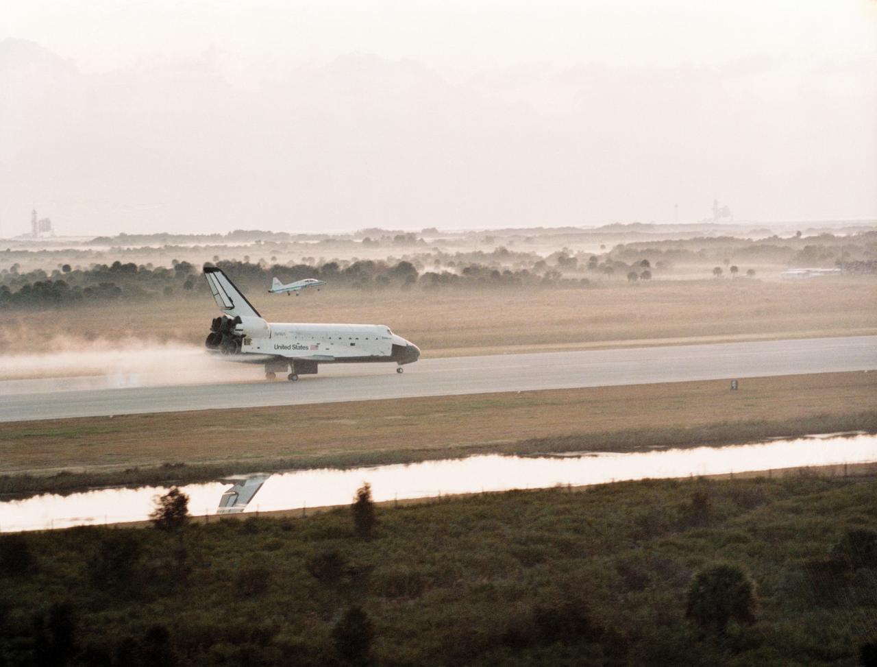 S84-27717 (11 Feb 1984) --- A chase plane gets a "front row" position to view the touchdown of the total landing gear of the Space Shuttle Challenger as the reusable spacecraft makes NASA's first landing on the runway at the Kennedy Space Center's (KSC) landing facility. This photograph was taken from another T-38 chase plane.