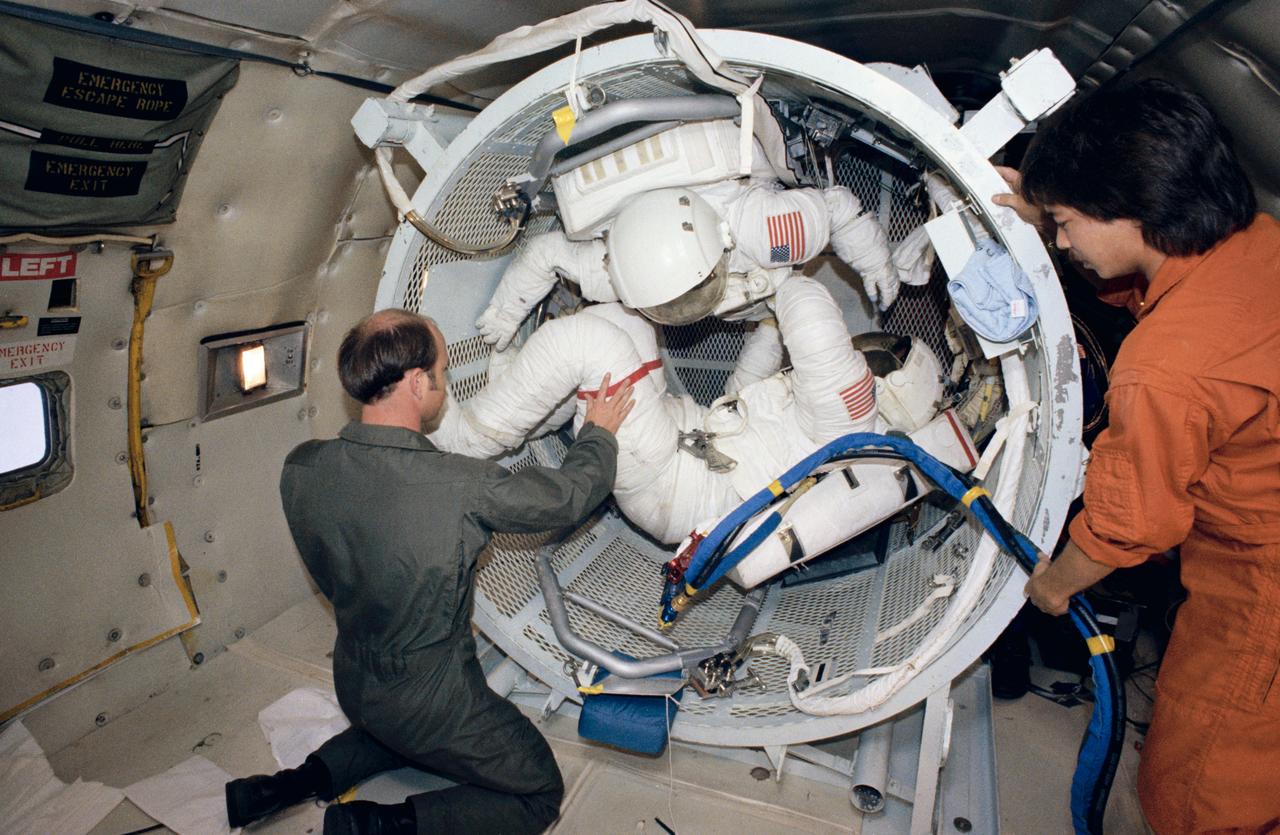 The 41-D crewmembers participate in suiting exercises in the weightless environment of the KC-135 aircraft.