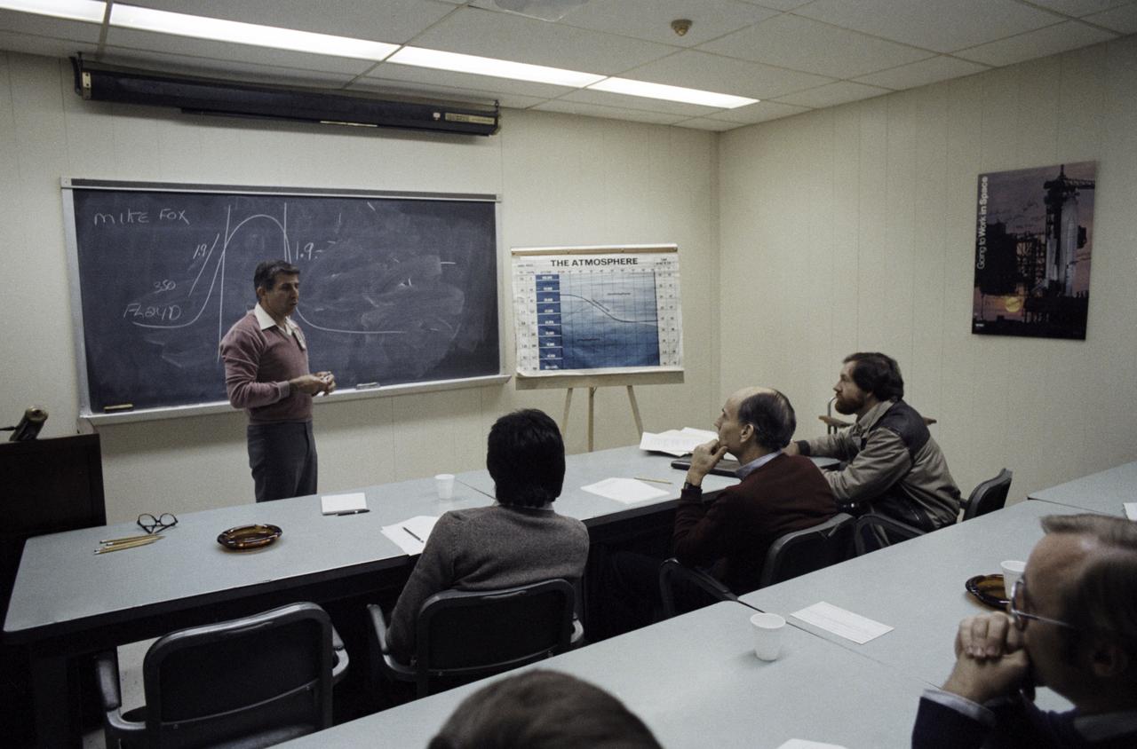 Senator Jake Garn (R., Utah), center on front row, listens to a briefing by Michael Fox, an Aeromedical Physiological Training Technician. Classroom activities in preparation for Vacuum Chamber Test. He is joined on the front row by Frank Martinez, a JSC safety diver and Jeff Bingham, the Senator's aide.           1. Senator E. J. "Jake" Garn          Also available in 35mm CN