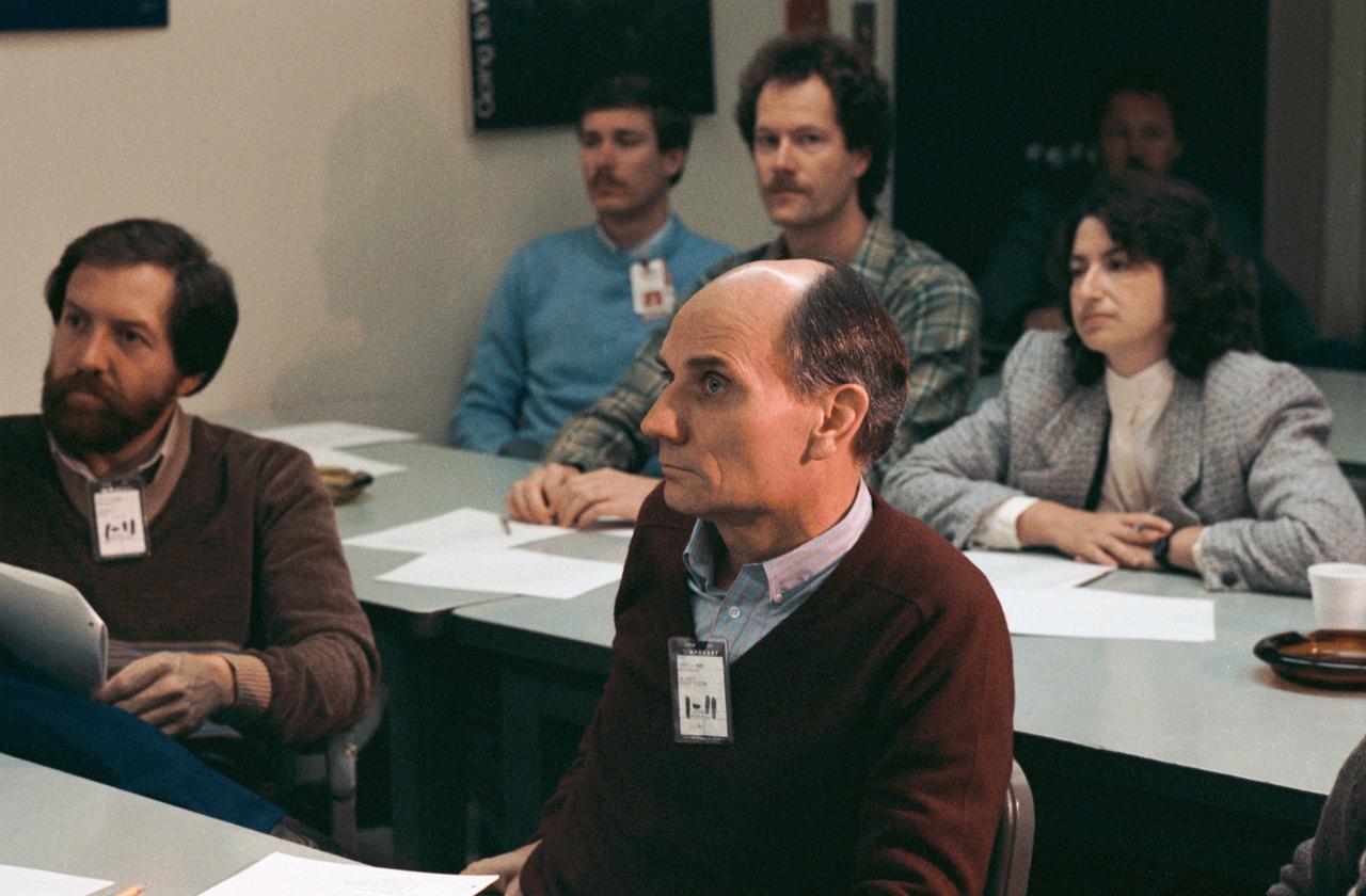 Senator Jake Garn (R., Utah), center on front row, listens to a briefing with Jeff Bingham, the Senator's aide. Garn and Binham on front row of conference table            1.  TRAINING - GARN, E. J. "JAKE", SEN.              Also available in 35 CN
