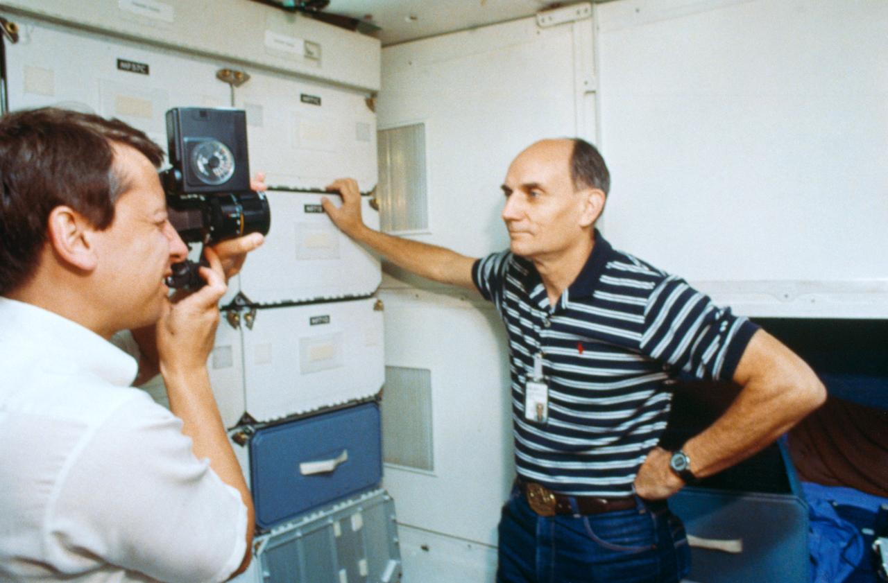 Two payload specialists for the STS 51-D mission get in some training time in the crew compartment trainerat JSC. Charles D. Walker, left, rehearses photography of U.S. Senator E.J. (Jake) Garn in the middeck section of the trainer.