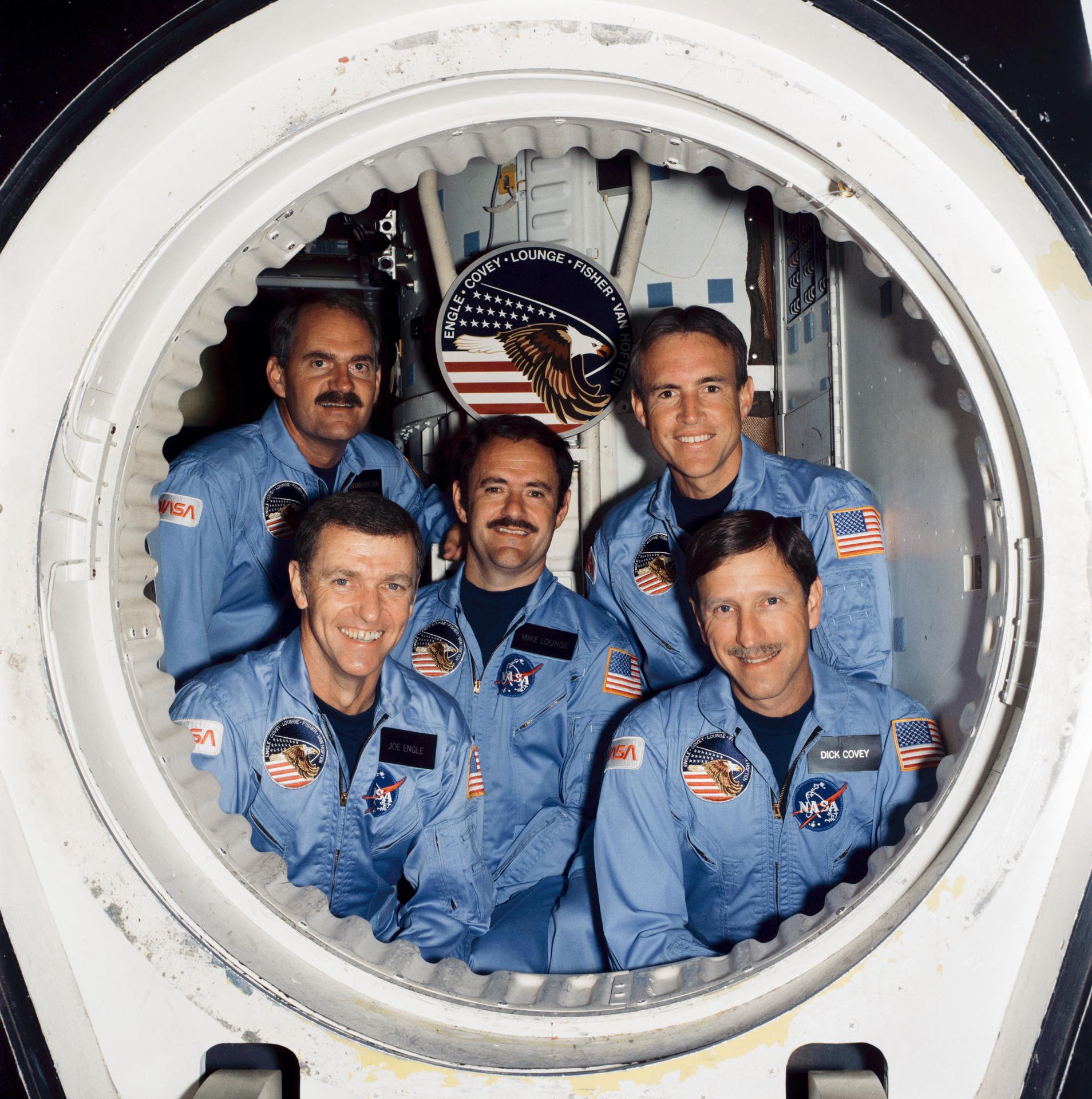 The five members of STS-51I's crew pose for a portrait from the crew compartment trainer at JSC.