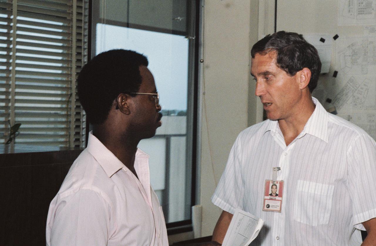 S85-40172 (5 Sept. 1985) --- Astronauts Ronald E. McNair (left), mission specialist, and Michael J. Smith, pilot, talk about their upcoming space mission in JSC's astronaut office. SINCE THIS PHOTOGRAPH WAS MADE: McNair, Smith and five other crew members lost their lives in the Challenger accident on Jan. 28, 1986. Photo credit: NASA