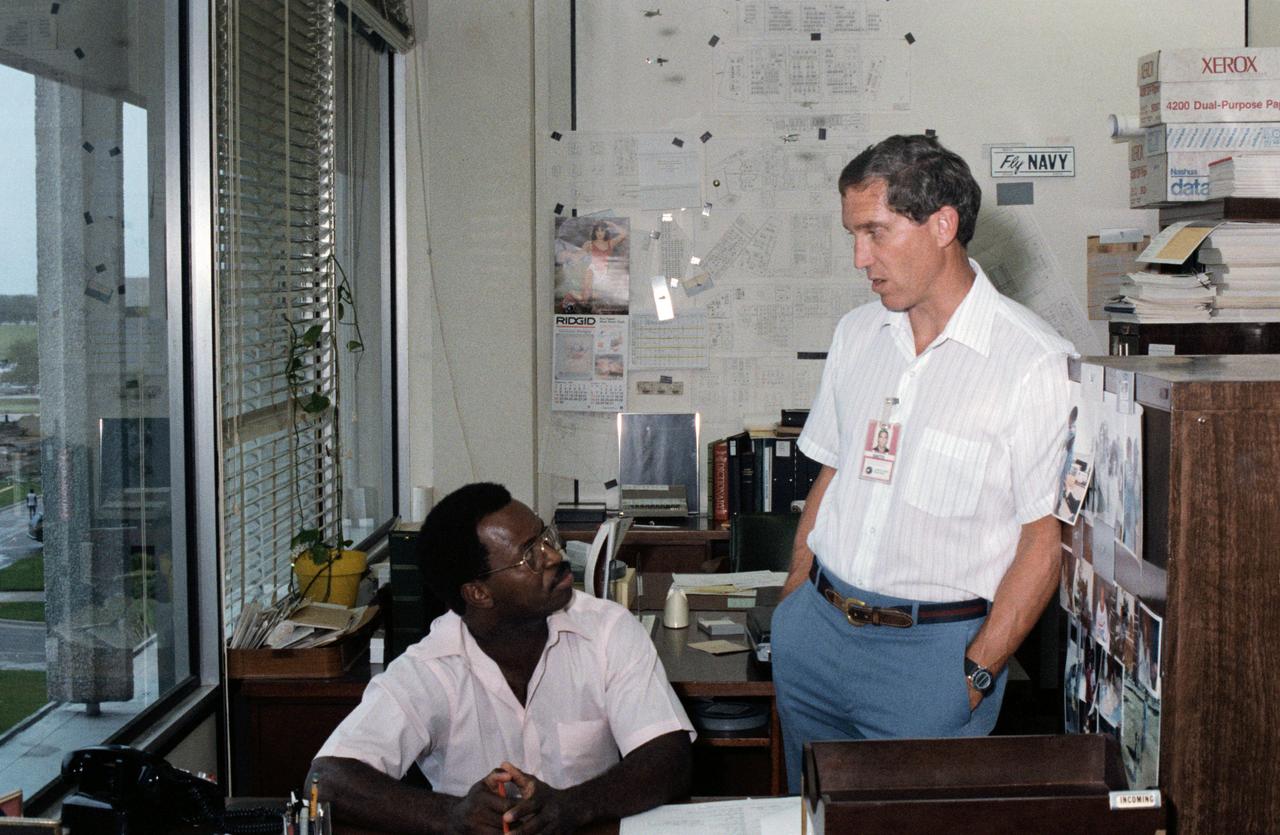 Candid views of the STS-33/51L Crew during study periods in their offices, 09/09/1985. Astronauts Michael J. Smith, STS-51L Pilot, and Ronald E. McNair, STS-51L Mission Specialist, are photographed in conversation while in training at JSC. JSC, HOUSTON, TX