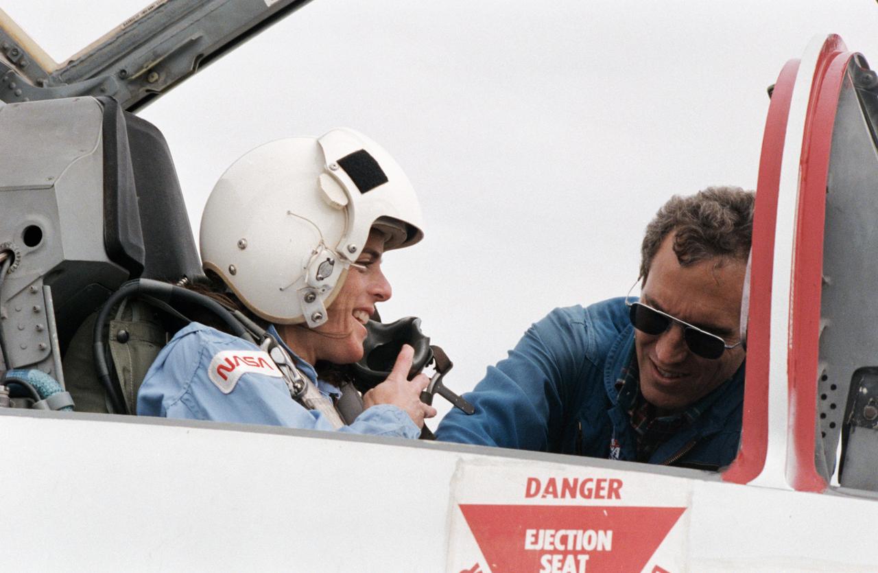 S85-41451 (3 Oct. 1985) --- Barbara Morgan, backup to the Teacher-in-Space participant Christa McAuliffe, prepares for a ride in the rear station of one of NASA's T-38 jet trainers at Ellington Field, near the Johnson Space Center (JSC). The McCall, Idaho teacher is briefed by astronaut Michael J. Smith, 51-L pilot, before departing Ellington Field. Photo credit: NASA