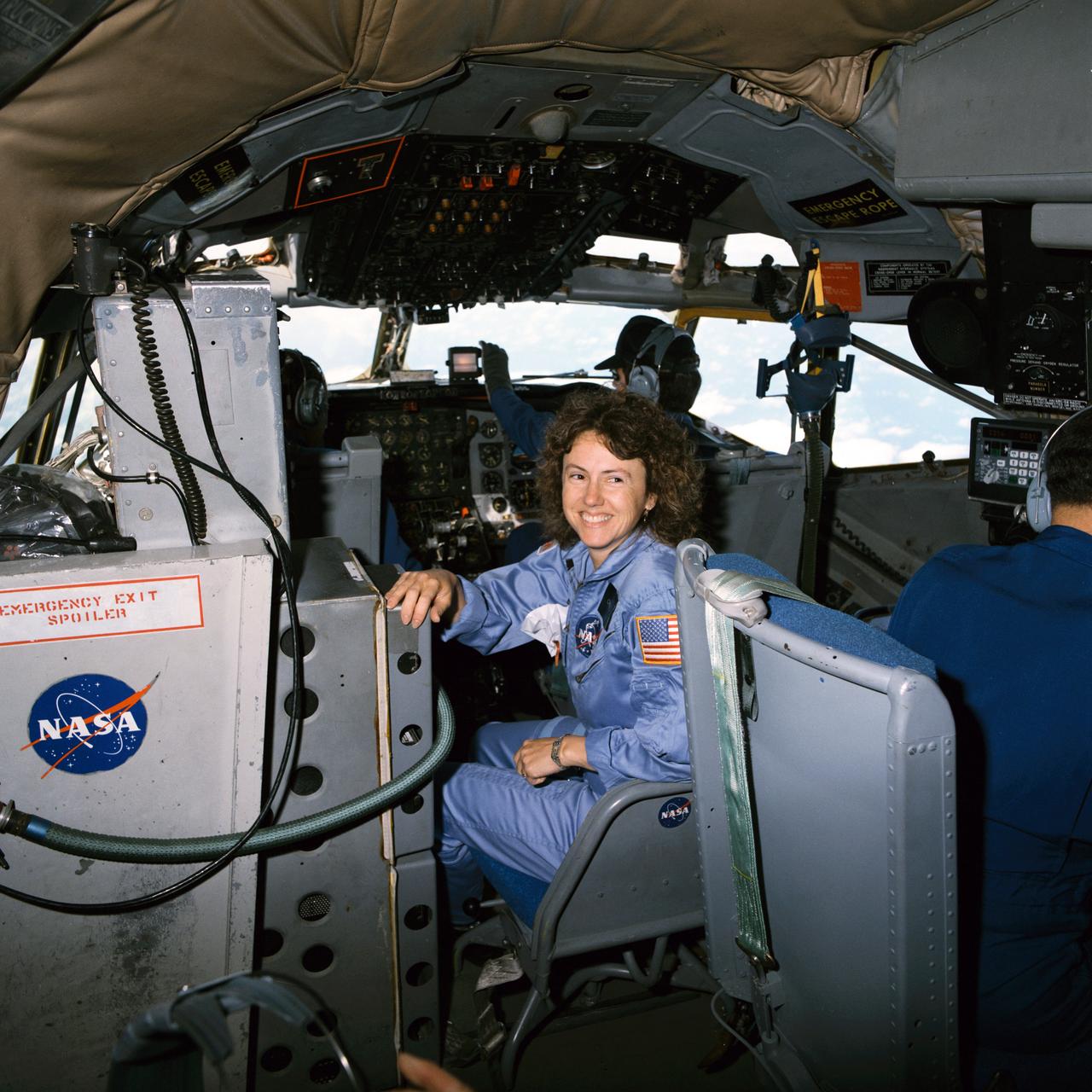 S85-42473 (16 Oct. 1985) --- Sharon Christa McAuliffe, a teacher-citizen observer on STS-51L, smiles before participating in some zero-G rehearsals for her upcoming flight. She is seated near the controls of the KC-135 aircraft, flying for the Johnson Space Center from Ellington Air Field. Referred to as the ?zero-gravity? aircraft, the KC-135 provides brief moments of weightlessness for shuttle crew members in training. Photo credit: NASA