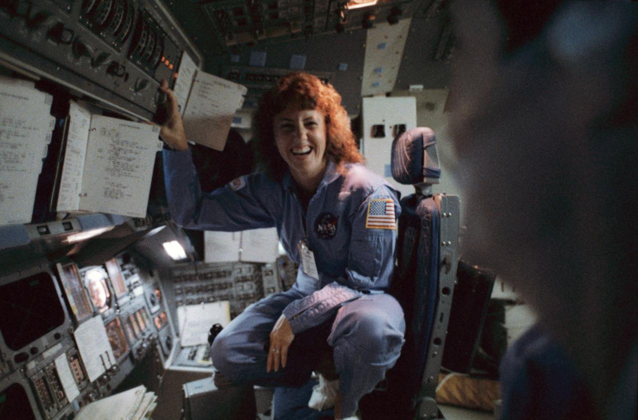 S85-44507 (October 1985) --- Sharon Christa McAuliffe, a teacher from Concord, New Hampshire, trains for the January 1986 mission of the space shuttle Challenger in the Johnson Space Center’s shuttle mission simulator (SMS). Learning about the overall spacecraft systems, McAuliffe is pictured here in the pilot’s station. For actual launch and landing phases, the Teacher-in-Space Project payload specialist would sit on the middeck. The photograph was taken by Michael O’Brien of Life Magazine. Photo credit: NASA