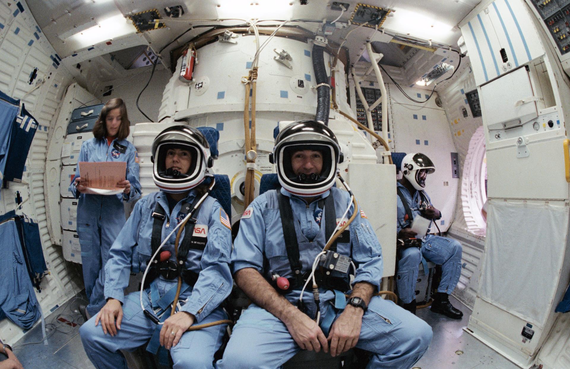 Christa McAuliffe and Gregory Jarvis sit in the shuttle simulator at JSC