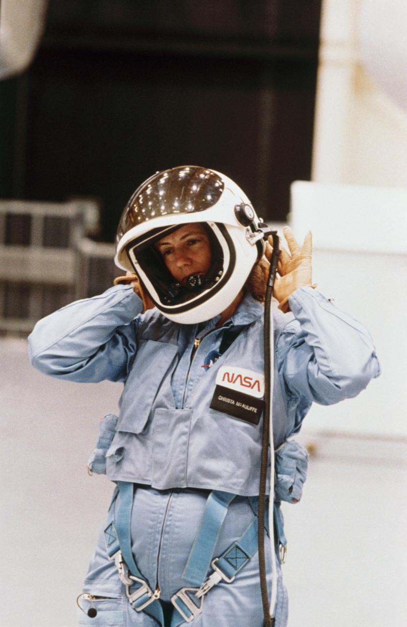 S86-25182 (for release January 1986) --- Sharon Christa McAuliffe, STS-51L citizen observer/payload specialist, prepares to remove her helmet after participating in emergency egress training in the shuttle mock-up and integration lab at the Johnson Space Center. McAuliffe will represent the Teacher-in-Space Project aboard the Challenger when it launches in late January. The photo was taken by Keith Meyers of the New York Times. Photo credit: NASA