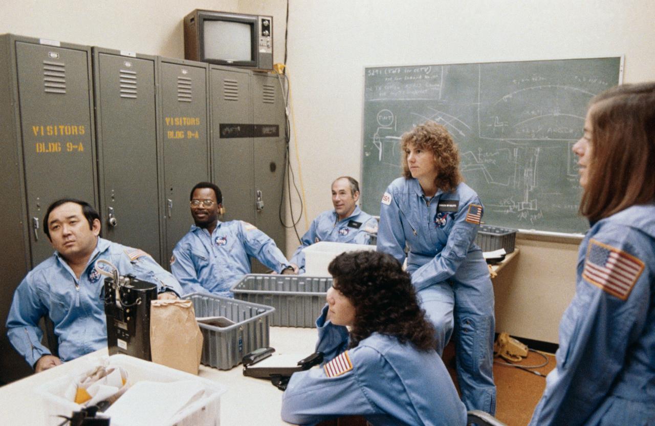 S86-25186 (December 1985) --- Five members of the prime crew for NASA?s STS-51L mission and a backup crew member are briefed during a training session in the Johnson Space Center?s (JSC) Shuttle Mock-up and Integration Laboratory. From left to right are astronaut Ellison S. Onizuka, mission specialist; Ronald E. McNair, mission specialist; Gregory D. Jarvis, Hughes payload specialist; Judith A. Resnik, mission specialist; Sharon Christa McAuliffe, citizen observer/payload specialist representing the Teacher-in-Space Project; and Barbara R. Morgan, backup payload specialist.  The photograph was taken by Keith Meyers of the New York Times.    EDITOR?S NOTE: The STS-51L crew members lost their lives in the space shuttle Challenger accident moments after launch on Jan. 28, 1986 from the Kennedy Space Center (KSC). Photo credit: NASA