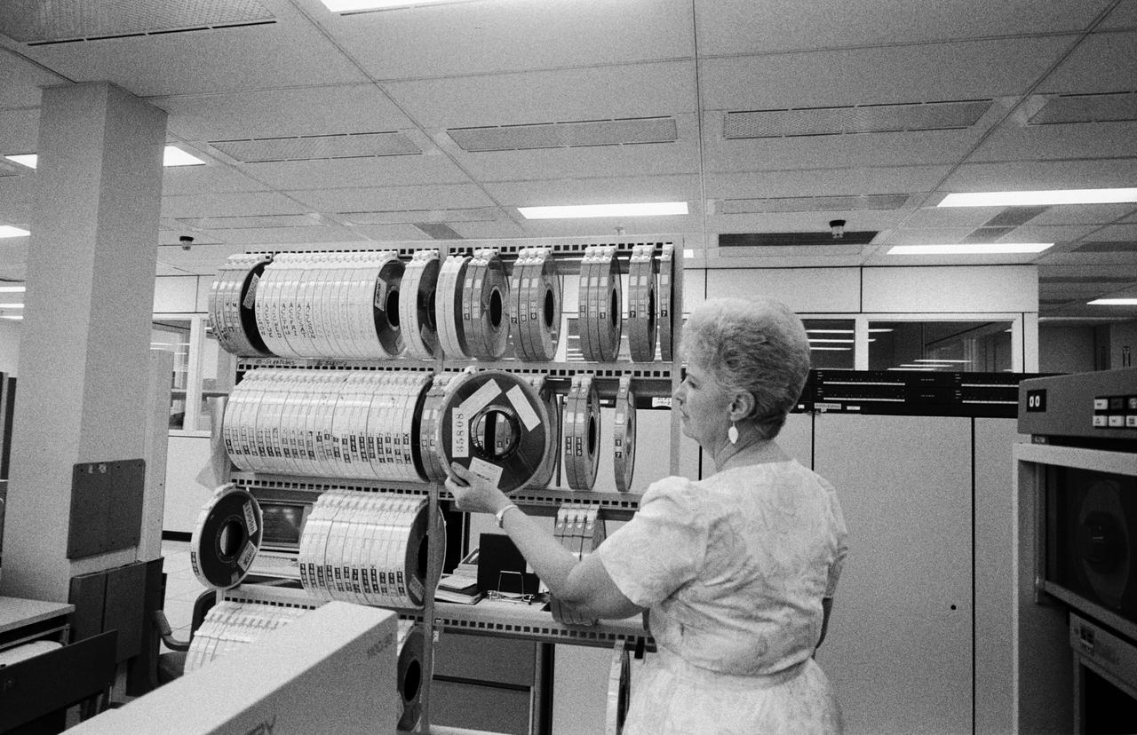 S86-30336 (4 April 1986) --- Larue Forbes of CSC retrieves one of the MADS tapes for inputting into a nearby computer in the central data office.