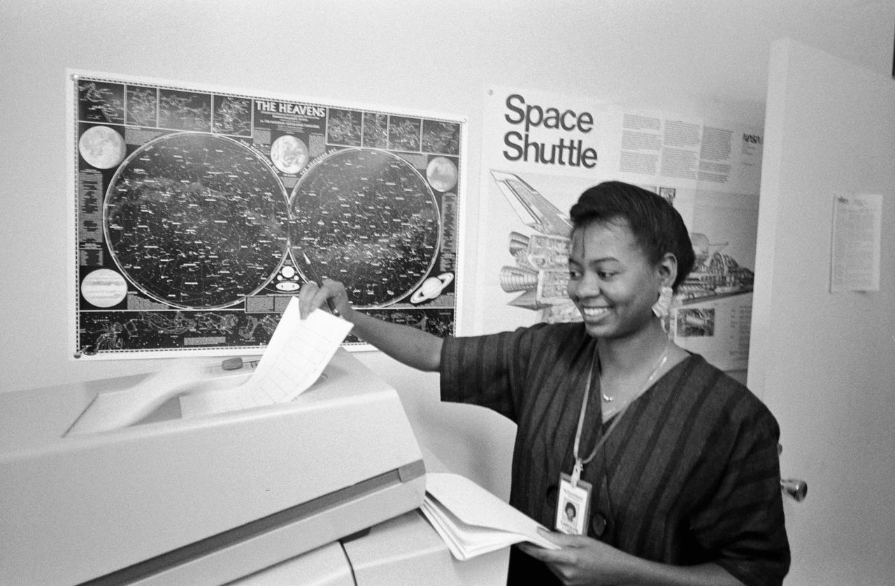 S86-30338 (4 April 1986) --- Carolyn Watson of Lockheed recieves a hard copy print-out of data from the MADS recorder as it is being sent form the termainal in JSC's central data office