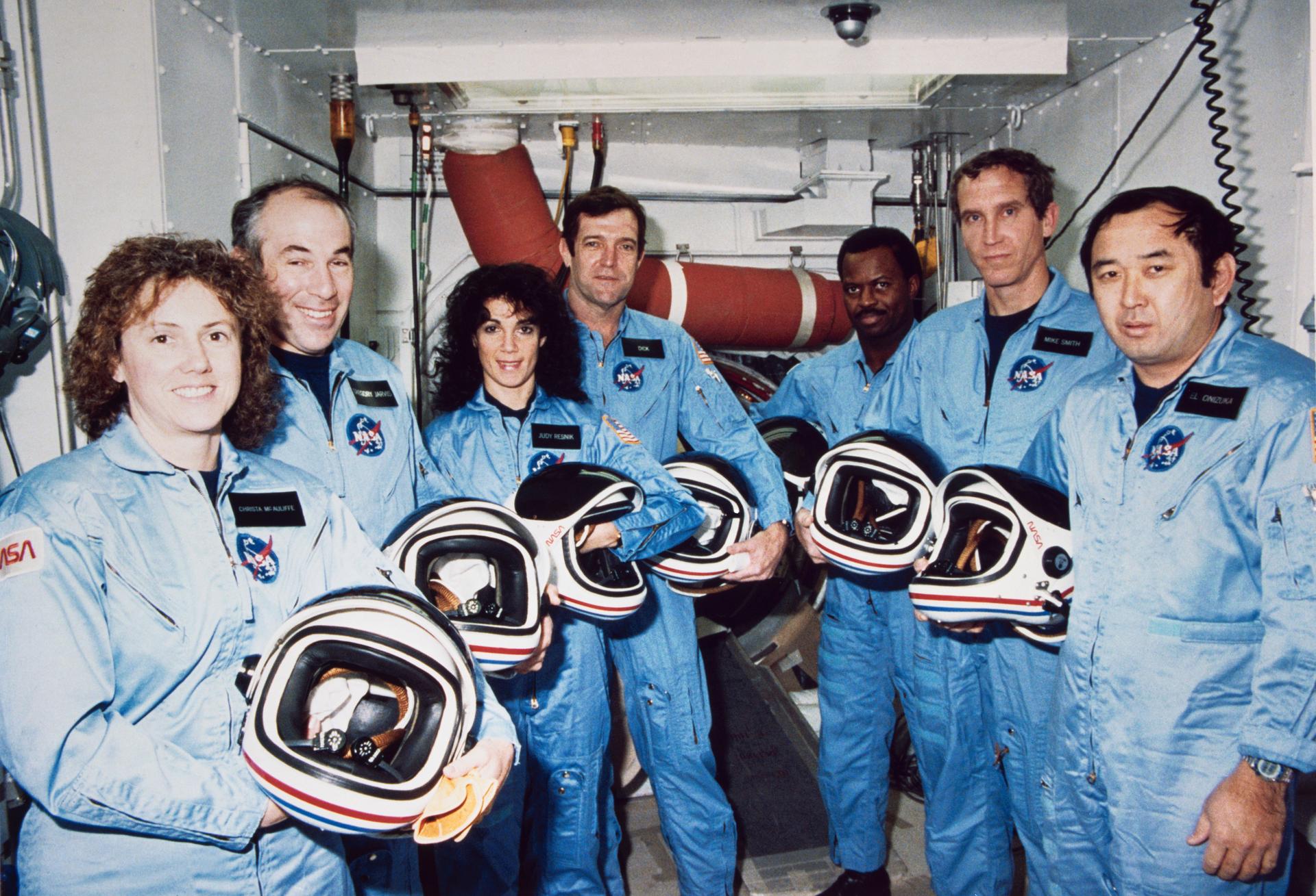 NASA's STS-51L crew members pose for photographs during a break in countdown training at the White Room, Launch Complex 39, Pad B. Left to right are Teacher-in-Space payload specialist Sharon Christa McAuliffe; payload specialist Gregory Jarvis; and astronauts Judith A. Resnik, mission specialist; Francis R. (Dick) Scobee, mission commander; Ronald E. McNair, mission specialist; Mike J. Smith, pilot; and Ellison S. Onizuka, mission specialist. EDITOR'S NOTE: The STS-51L crew lost their lives in an explosion, onboard the space shuttle Challenger, following launch Jan. 28, 1986.