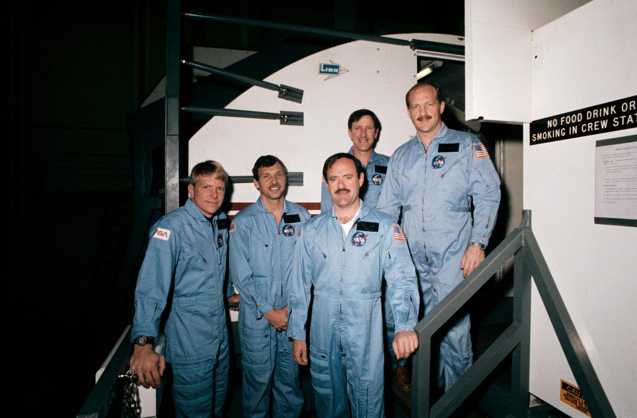 S87-26822 (11 Feb. 1987) --- The Return to Flight crew, STS-26 pose for a photo prior to a training session in a simulator in the Jake Garn Mission Simulation and Training Facility at the Johnson Space Center. Photo credit: NASA