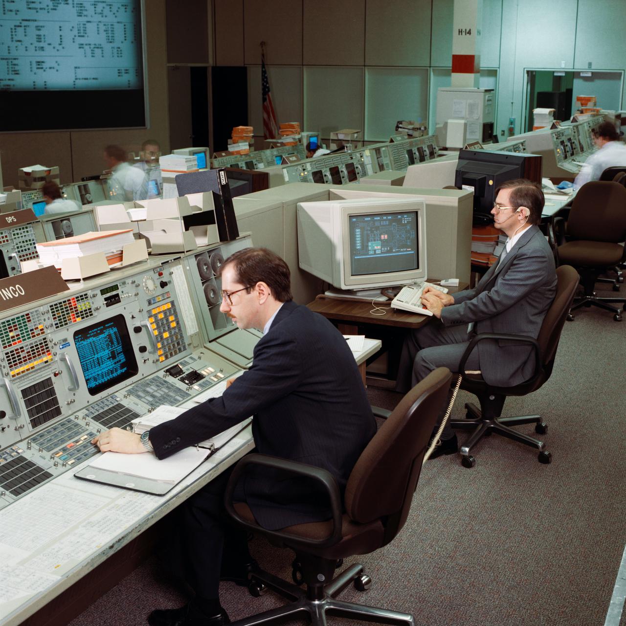 Instrumentation and Communications Officer (INCO) John F. Muratore monitors conventional workstation displays during an STS-26 simulation in JSC Mission Control Center (MCC) Bldg 30 Flight Control Room (FCR). Next to Muratore an operator views the real time data system (RTDS), an expert system. During the STS-29 mission two conventional monochrome console display units will be removed and replaced with RTDS displays. View is for the STS-29 press kit from Office of Aeronautics and Space Technology (OAST) RTDS.