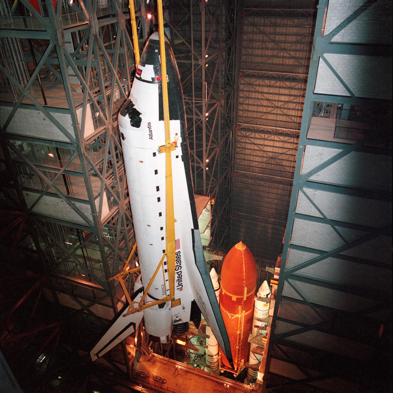 STS-27 Atlantis, Orbiter Vehicle (OV) 104, is suspended via overhead crane, attached at four points, in the Kennedy Space Center (KSC) Vehicle Assembly Building (VAB). Below OV-104 on the mobile launcher platform are the external tank (ET) and solid rocket boosters (SRBs). During ET/SRB mating operations, OV-104 will be mounted atop the ET.