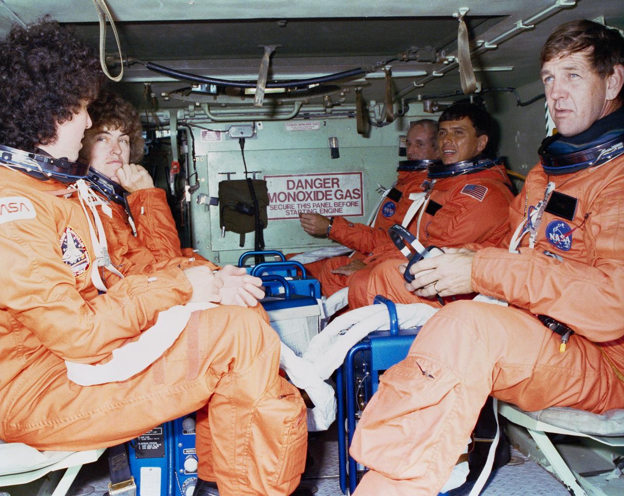 STS-34 crewmembers sit in M1-13 Armored Personnel Carrier (APC) during emergency egress training at KSC's shuttle landing facility (SLF) prior to terminal countdown demonstration test (TCDT) activities. Wearing launch and entry suits (LESs), are (from left) Mission Specialist (MS) Ellen S. Baker, MS Shannon W. Lucid, Commander Donald E. Williams (right side, in back), MS Franklin R. Chang-Diaz, and Pilot Michael J. McCulley (holding headset). View provided by KSC with alternate number KSC-89PC-871.