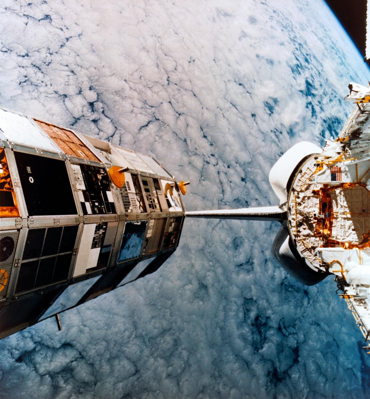Photo from Space Shuttle Mission 41-C of the Long Duration Exposure Facility (LDEF) deploy by CHALLENGER and a Langley Research Center (LRC) supplied art concept of the LDEF recovery by COLUMBIA during Space Shuttle Mission STS-32. LRC # L-89-11-720 for JSC # S89-50779