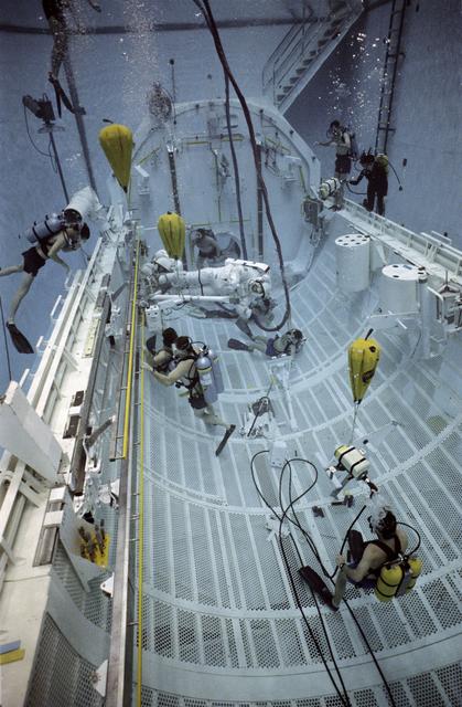 NASA image: STS-37 crewmembers move CETA electrical cart along rail in JSC's WETF pool