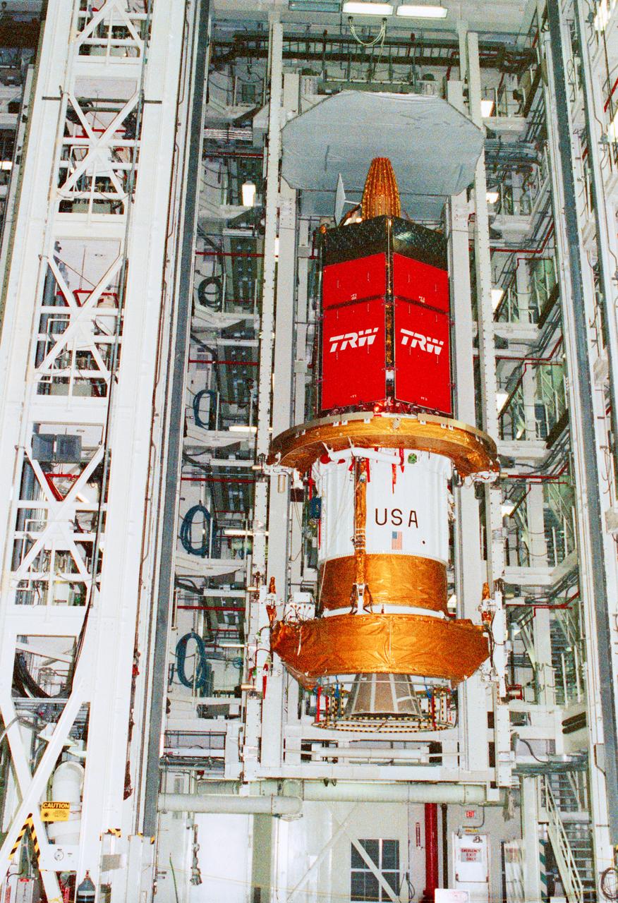 STS-43 Tracking and Data Relay Satellite E (TDRS-E) undergoes preflight processing in the Kennedy Space Center's (KSC's) Vertical Processing Facility (VPF) before being loaded into a payload canister for transfer to the launch pad and eventually into Atlantis', Orbiter Vehicle (OV) 104's, payload bay (PLB). This side of the TDRS-E will rest at the bottom of the PLB therefore the airborne support equipment (ASE) forward frame keel pin (at center of spacecraft) and the umbilical boom running between the two ASE frames are visible. The solar array panels are covered with protective TRW shields. Above the shields the stowed antenna and solar sail are visible. The inertial upper stage (IUS) booster is the white portion of the spacecraft and rests in the ASE forward frame and ASE aft frame tilt actuator (AFTA) frame (at the bottom of the IUS). The IUS booster nozzle extends beyond the AFTA frame. View provided by KSC with alternate number KSC-91PC-1079.