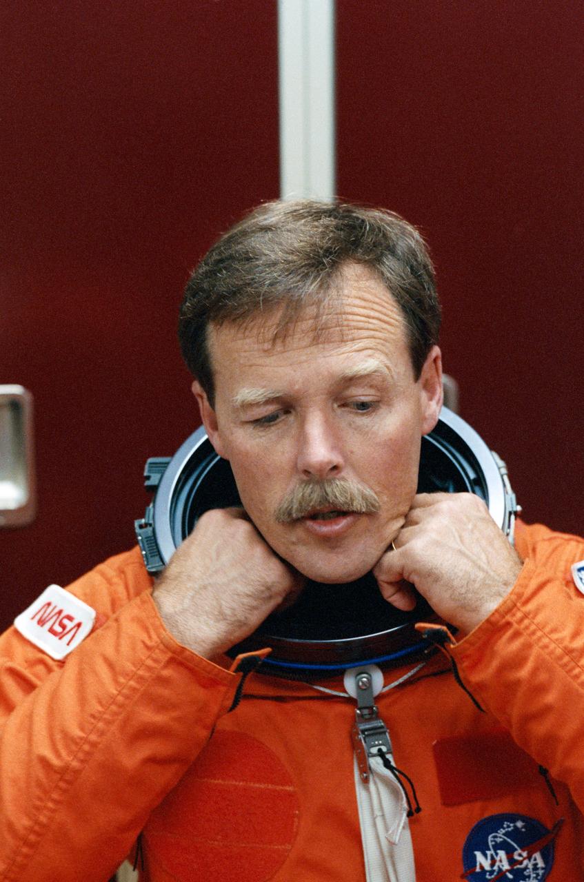 STS-47 Endeavour, Orbiter Vehicle (OV) 105, Commander Robert L. Gibson adjusts the launch and entry suit (LES) neck dam during suit donning in JSC's Mockup and Integration Laboratory (MAIL) Bldg 9A. Gibson is preparing for launch emergency egress (bailout) exercises in the Crew Compartment Trainer (CCT).