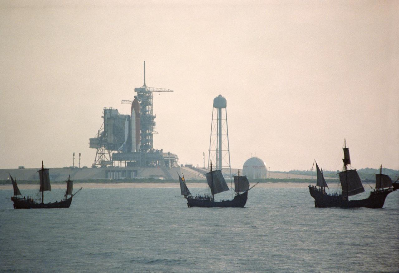 S92-39074 (6 May 1992) --- The centuries-old technology that built Christopher Columbus' three sailing ships passes within a half mile of the 20th-Century Space Shuttle Endeavour, in background, awaiting liftoff on Launch Pad 39B. The replicas of the Santa Maria, Nina, and Pinta wind-powered ships, managed by the Spain '92 Foundation, are on a tour to ports around the Gulf of Mexico and up the Atlantic Coast of the United States. Endeavour is set to lift off on its maiden voyage, STS-49, on May 7, 1992. Video footage of the two types of exploration vessels will be used by NASA for a variety of productions, including the annual Von Braun Exploration forum sponsored by NASA's Marshall Space Flight Center (MSFC), Huntsville, Alabama, in October, 1992. This year's theme is Exploration and the Evolution of Nations. 1992 is the 500th anniversary of Columbus' voyage to the New World.